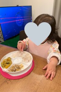 オクソートットのくっつくランチプレートを使ってご飯を食べる子供